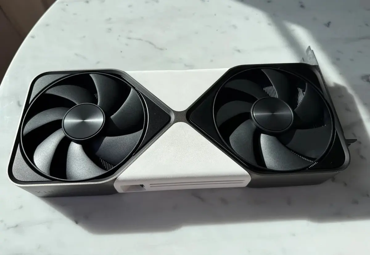 RTX 5080 Founders Edition en blanc : un mod audacieux relance la question pour NVIDIA 12 Carte graphique RTX 5080 Founders Edition modifiée en blanc, vue de profil sur un bureau, ventilateur et carénage personnalis