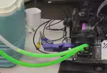 Carte graphique Intel Arc B580 overclockée au liquide antigel, tubes de watercooling visibles, affichant un gain de 16 % et u