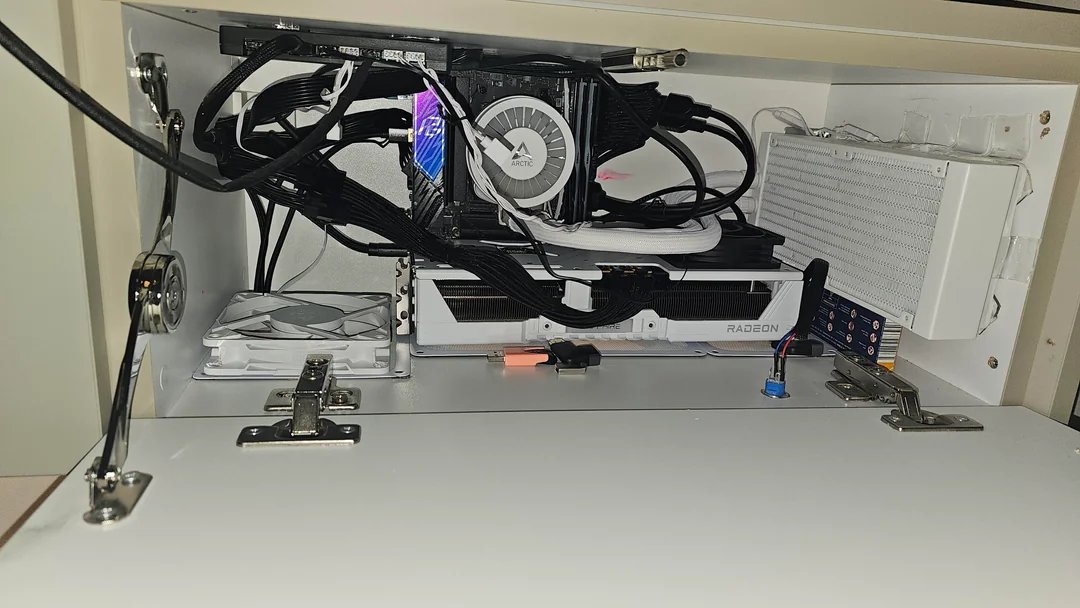 Radeon RX 9070 XT mini‑ITX cachée dans un meuble TV : un PC gaming furtif 2 Vue latérale d'un PC mini‑ITX dissimulé dans un meuble TV avec une carte Radeon RX 9070 XT visible, câblage et ventilation re