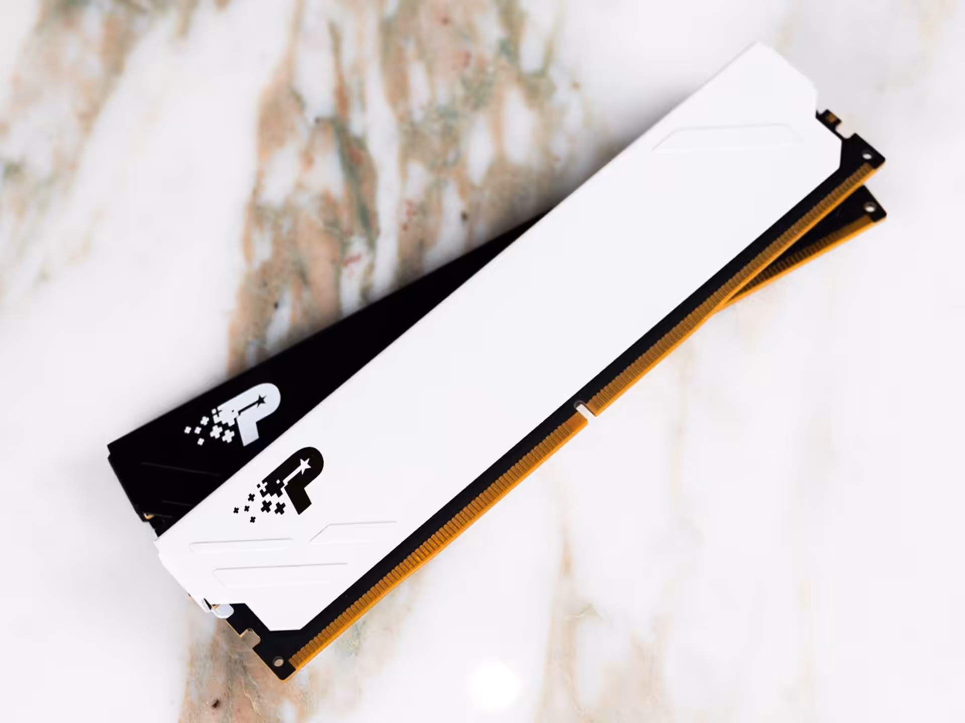 Patriot Viper Xtreme 5 Aurum Edition : DDR5 dorée jusqu’à 64 Go à 8000 MT/s 32 Barre de RAM blanche et noire avec logo P sur surface marbrée.