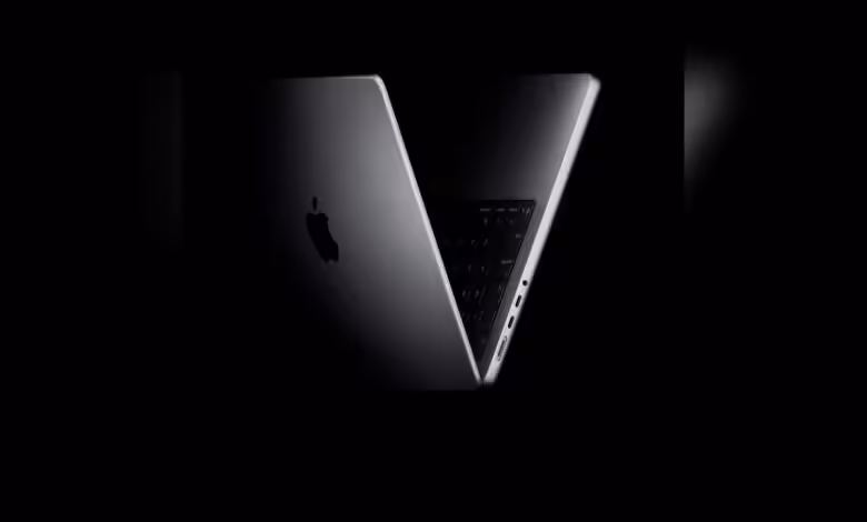 Apple M6 : possible lancement avancé fin 2026, MacBook Pro OLED et iPad en ligne de mire 1 MacBook Apple ouvert en vue arrière sur fond noir.
