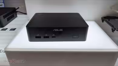 Mini PC ASUS NUC 16 Pro présenté sur une plateforme lumineuse avec port USB visible.