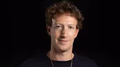 Personne portant un pull noir sur fond noir, regardant vers l'avant.