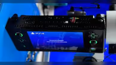 PS4 Slim transformée en appareil portable avec écran allumé, boutons visibles, fond bleu contrasté