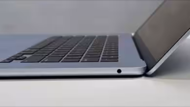 Vue latérale d'un MacBook Air ouvert avec clavier et châssis visibles.