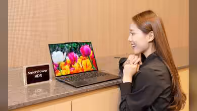 Ordinateur portable avec écran SmartPower HDR affichant des tulipes, femme souriante à côté