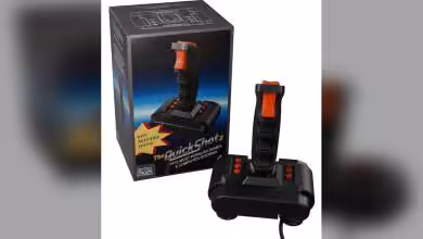 Packaging et joystick The QuickShot II en gros plan avec boutons rouges.