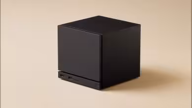 Cube noir minimaliste, appareil tech avec ports USB visibles.