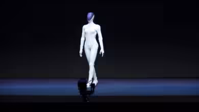 Présentation d'un robot humanoïde blanc sur une scène sombre.