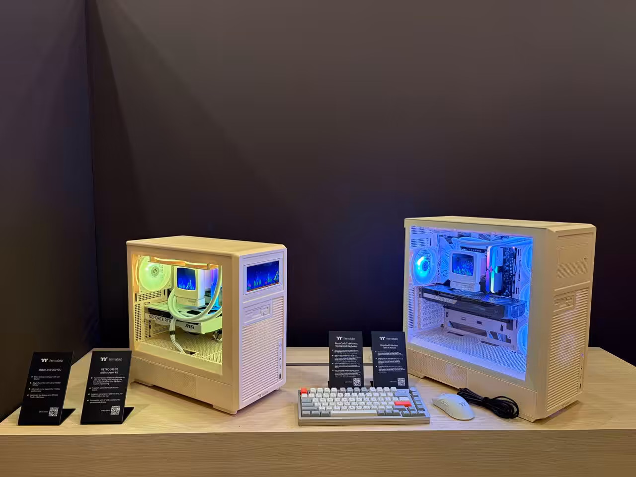 Boîtiers Thermaltake Retro Series avec éclairage RGB sur table en bois.