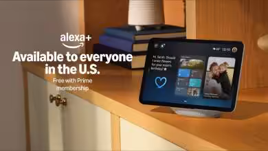 Écran smart Amazon Echo Show affichant Alexa+ sur une étagère en bois, montre applications et messages.