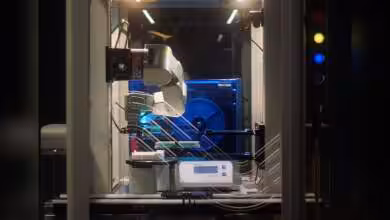 Machine robotique dans un laboratoire avec bras automate et écran numérique.