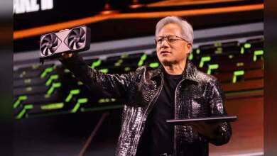 Carte graphique NVIDIA avec double ventilateur tenue par une personne sur scène.