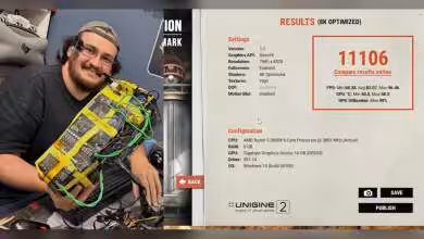 Homme souriant tenant une carte graphique modifiée, configuration visible à l'écran, environnement laboratoire.