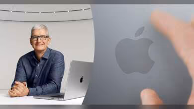 Tim Cook assis près d'un MacBook Apple avec une main pointant sur le logo Apple.