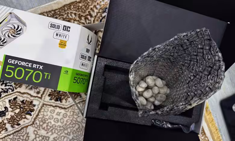 GeForce RTX 5070 Ti : un acheteur Amazon reçoit… des cailloux à la place d’une Zotac blanche 1 Boîte Zotac GeForce RTX 5070 Ti et sac de cailloux dans emballage.