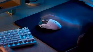 Souris de jeu Logitech G à côté d'un clavier, sur tapis de souris.