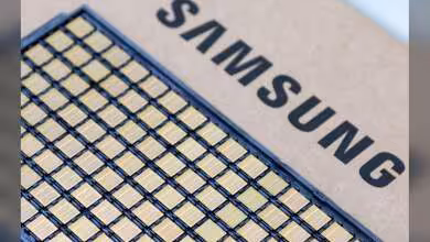 Puces mémoire HBM4E sur carton avec logo Samsung visible en arrière-plan.