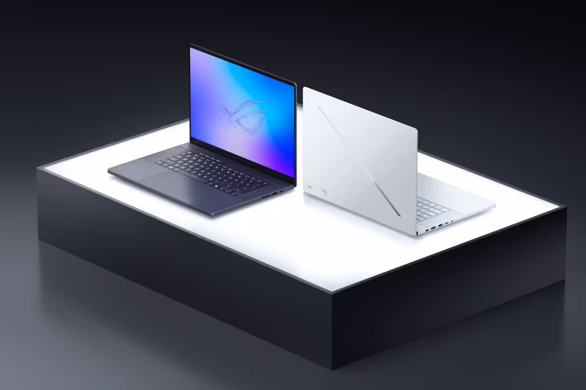 Deux portables ASUS ROG sur socle blanc, un ouvert écran violet, l'autre fermé.