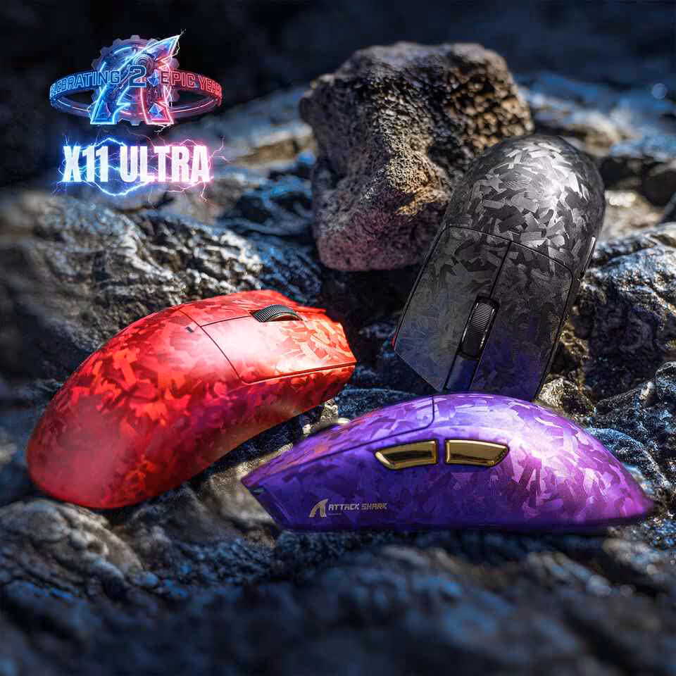 Trois souris Attack Shark X11 ULTRA dans des couleurs camo noir, rouge et violet sur un fond rocheux.