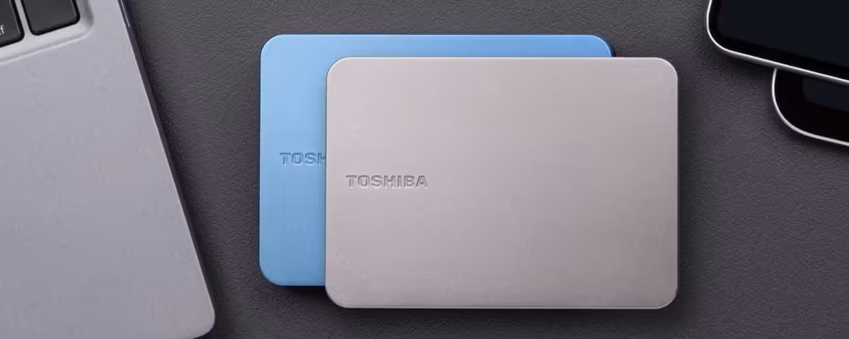 Deux disques durs Toshiba Canvio Flex argenté et bleu sur une table.