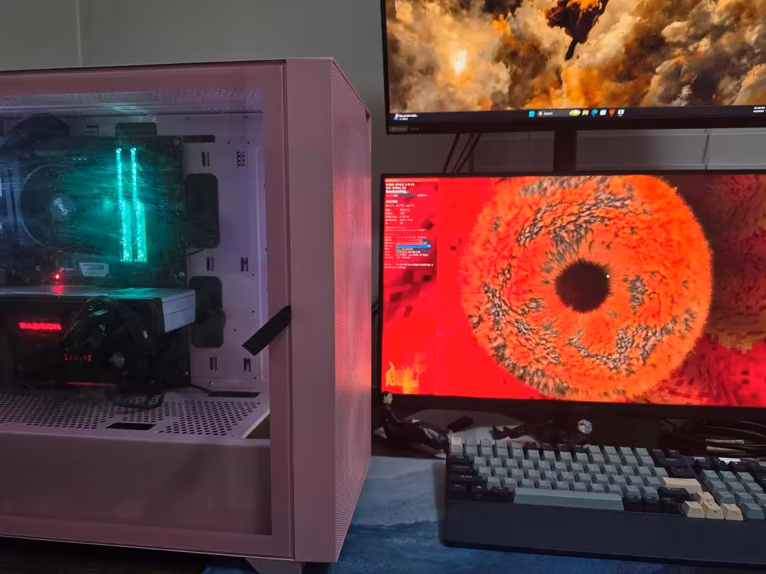 Configuration PC rose avec double écran, jeu affiché sur le moniteur