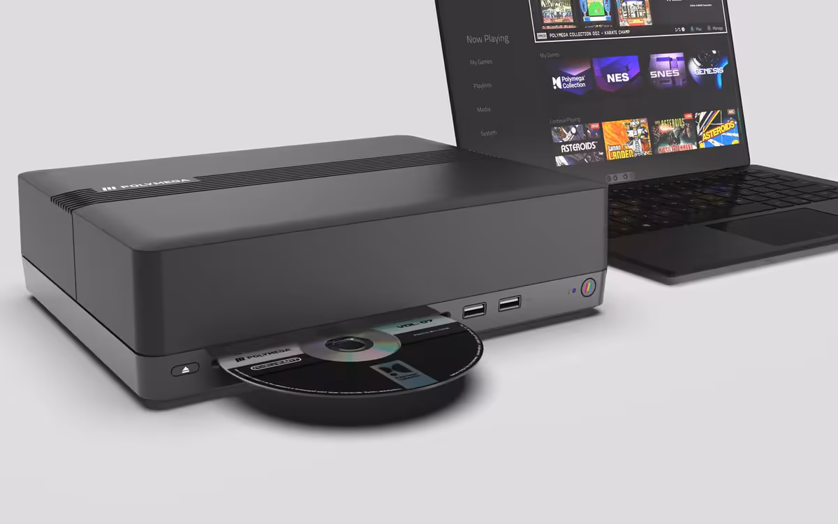 Module Polymega avec CD inséré, à côté d'un ordinateur portable affichant un écran de jeux.