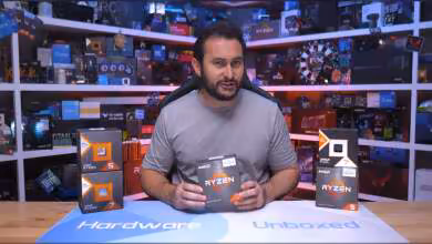 Homme tenant boîtes CPU AMD Ryzen avec nombreux produits en arrière-plan, éclairage net.