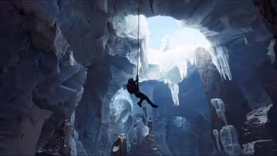 Personnage dans une grotte glacée suspendu à une corde.