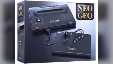 Packaging console NEOGEO AES+ avec manette arcade, logo SNK visible.