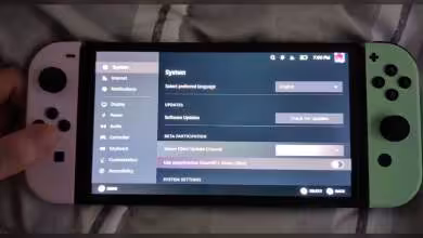 Console de jeu portable avec écran affichant les paramètres Steam, joysticks colorés rose et vert
