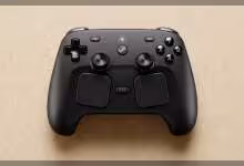 Steam Controller noir sur fond beige, bien cadré, éclairage diffus