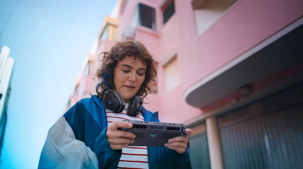 Personne utilisant console portable en extérieur immeuble rose