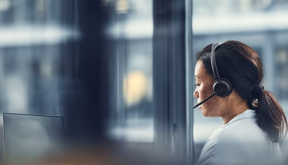 Utilisatrice avec casque-micro EPOS en open space, devant un ordinateur portable