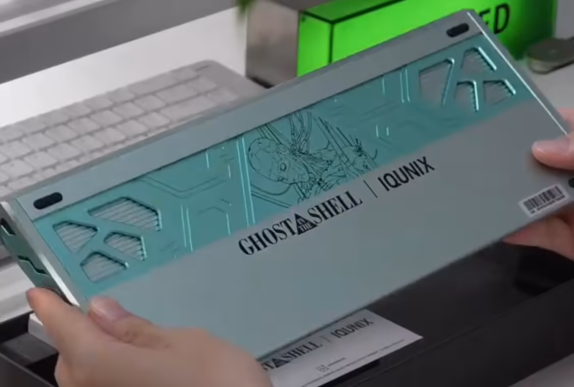 Boîtier ou plaque IQUNIX Ghost in the Shell vert menthe, branding EV63 visible.