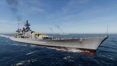 Croiseur de guerre gris en vue de proue sur mer calme, avec superstructure détaillée et arrière-plan côtier
