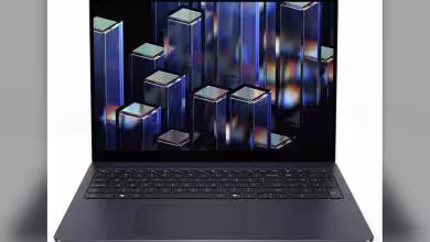 PC portable Dell gris foncé, vue de face, clavier complet et écran affichant des motifs colorés