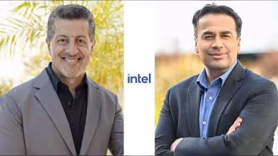 Deux hommes en costume posant côte à côte, logo Intel au centre.