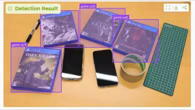 Quatre boîtiers de jeux PS4 avec deux smartphones et objets de bureau sur une table.