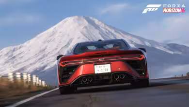 Voiture sportive rouge dans Forza Horizon 6 avec montagne en arrière-plan, ciel bleu.