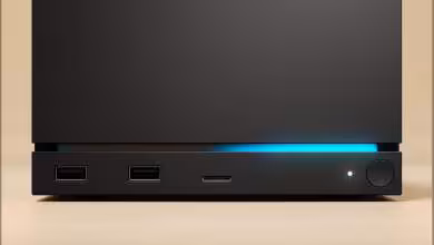 Steam Machine noire en façade, ports USB et bouton d’alimentation avec bande lumineuse bleue.