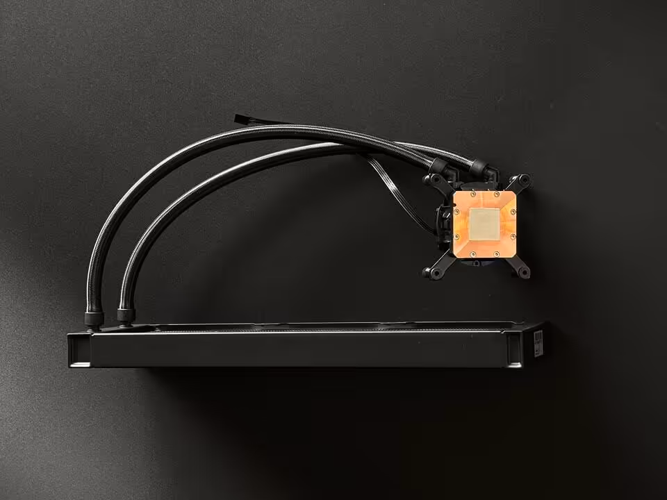 AIO Asetek Emma V3 : 1,5 °C de mieux et 45 % de bruit perçu en moins au Computex 2026 4 Radiateur AIO Asetek Emma V3 avec deux tuyaux noirs et waterblock monté