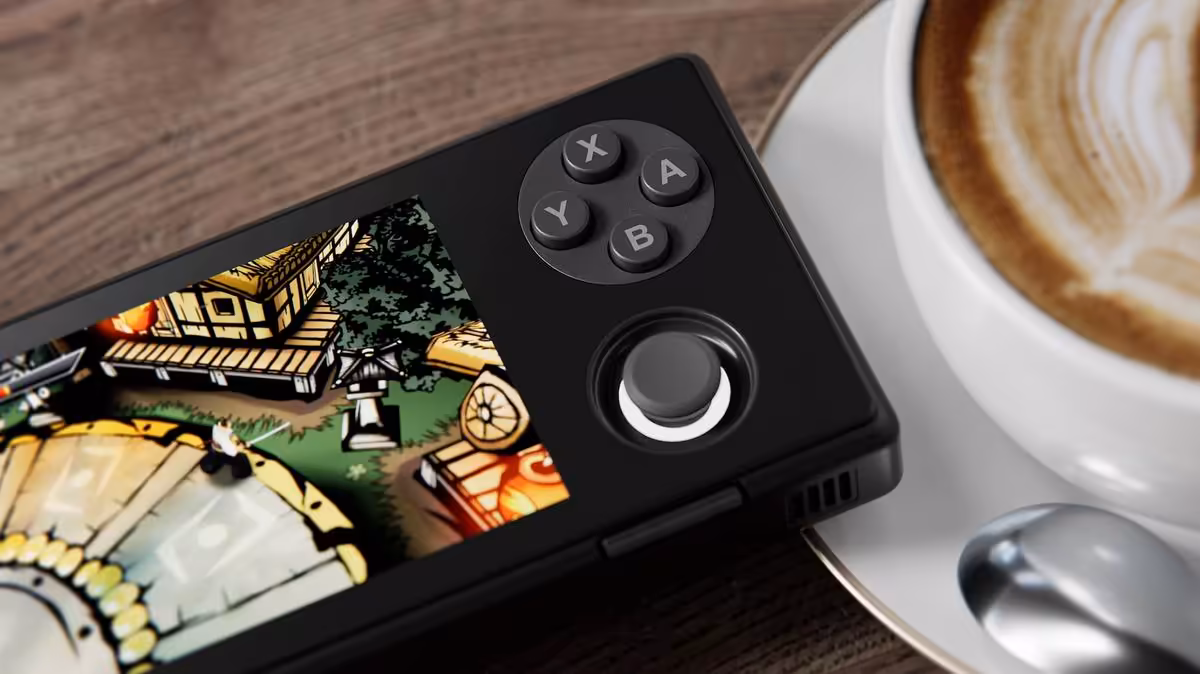 Console portable AYANEO Pocket Micro 2 noire en situation d’usage près d’une tasse de café