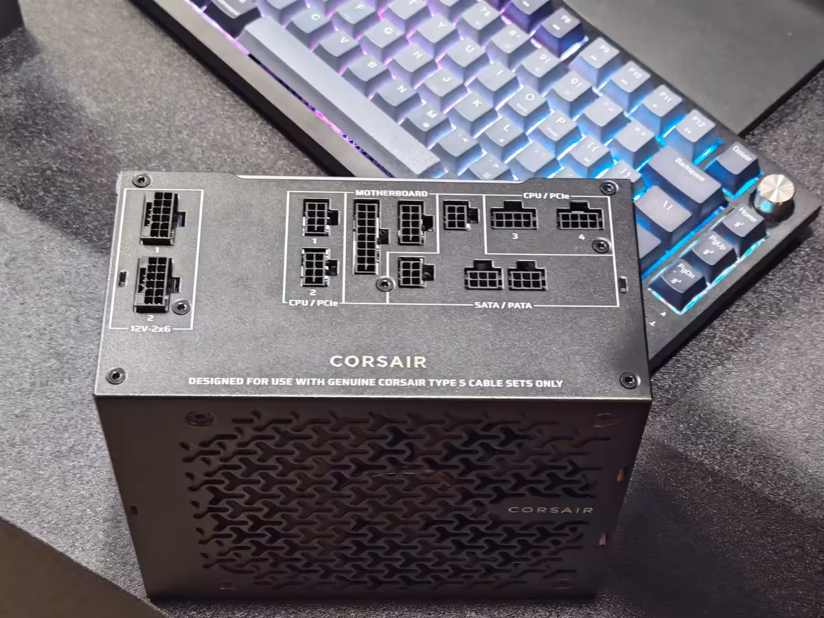 Corsair AX1600i SHIFT : 1600 W en 170 mm, la densité impose ses choix de câblage 3 Panneau connecteurs latéraux de l’alimentation Corsair AX1600i SHIFT, marquages CPU/PCIe et SATA/PATA visibles.