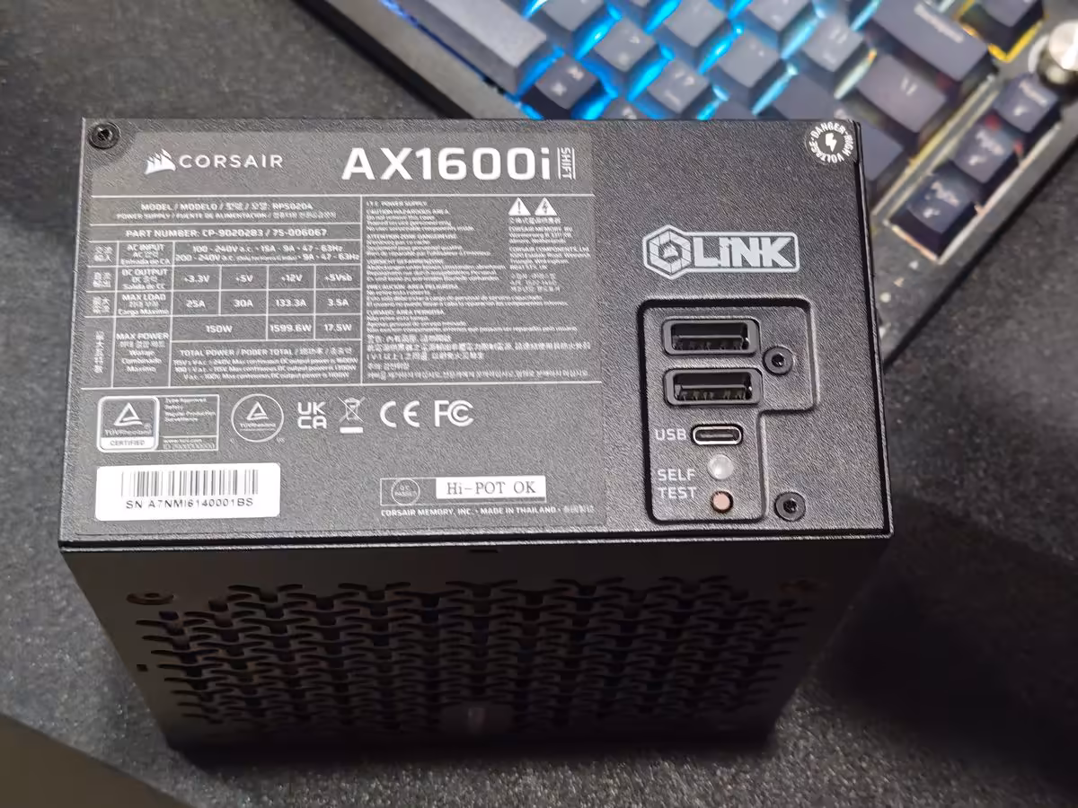 Corsair AX1600i SHIFT : 1600 W en 170 mm, la densité impose ses choix de câblage 4 Connecteurs et interfaces de l’alimentation Corsair AX1600i SHIFT : iCUE LINK, USB et bouton SELF TEST visibles.