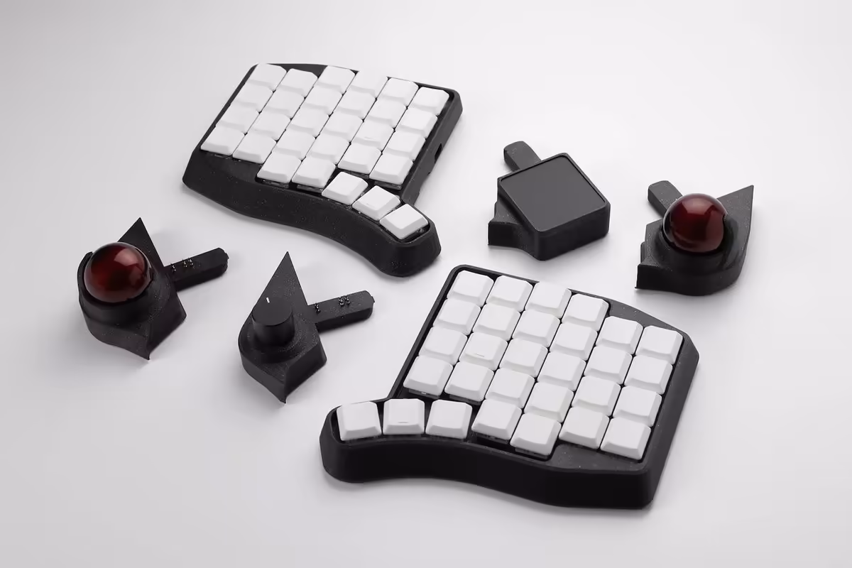 Ensemble de clavier split ergonomique noir et blanc avec deux trackballs rouges et pavés détachés