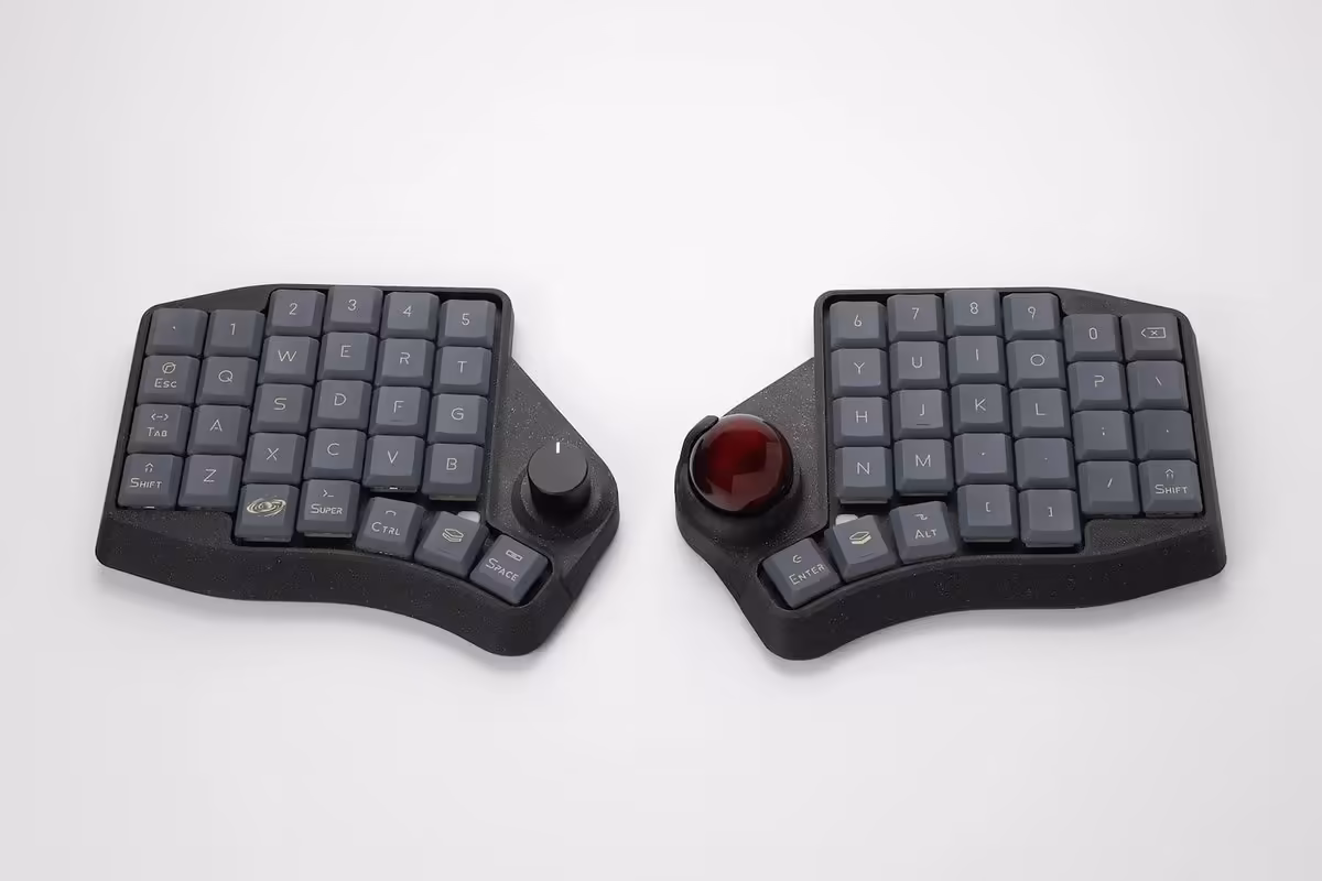 Clavier ergonomique scindé noir avec keycaps gris foncé et trackball rouge sur la moitié droite