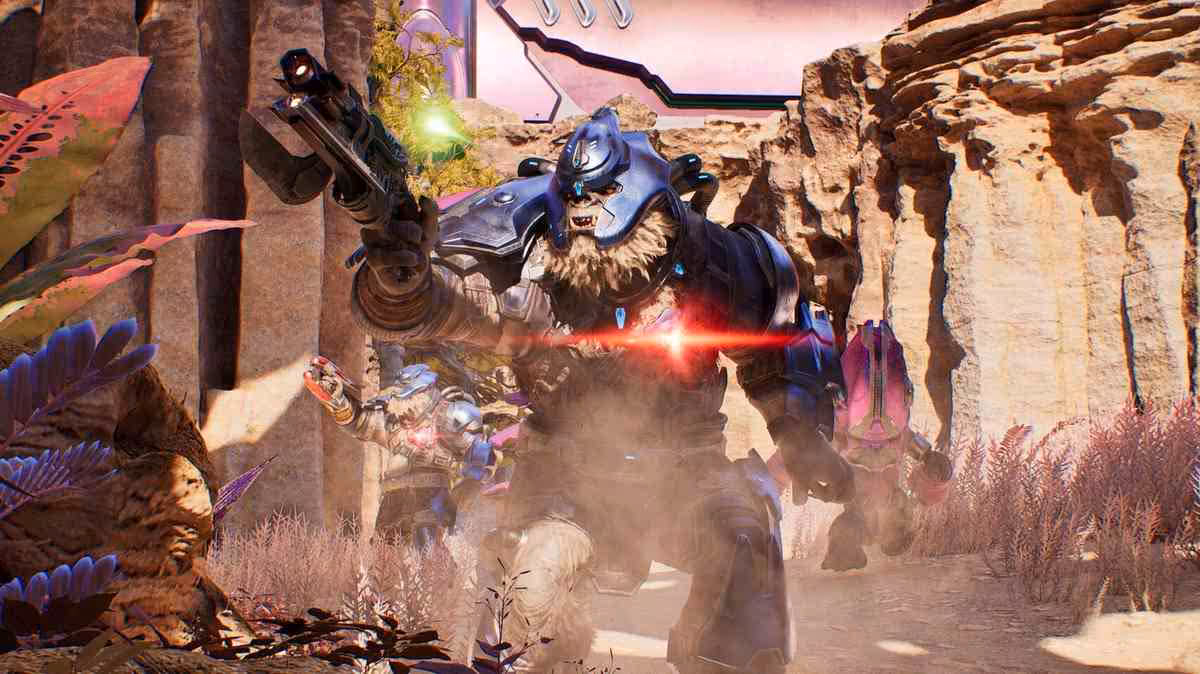 Elite de Halo combattant dans un décor désertique rocheux, explosion et tirs visibles autour de lui