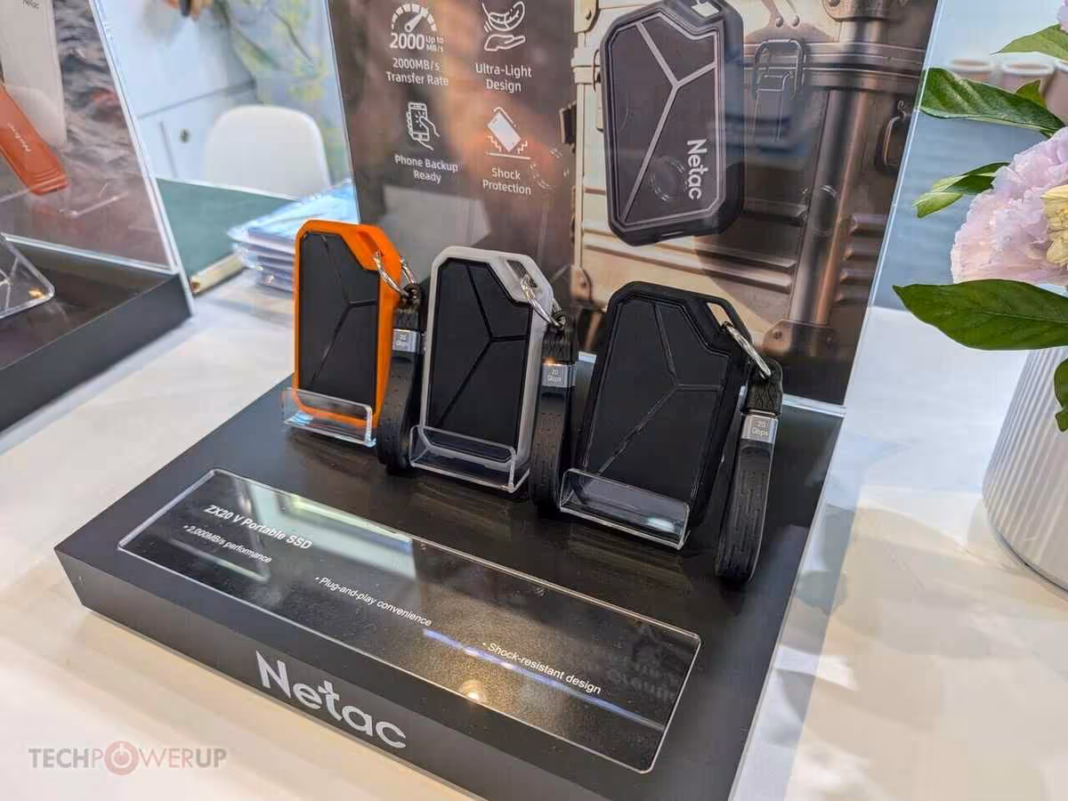 Netac Computex 2026 : DDR5-7600, SSD U.3 jusqu’à 30,72 To et dock 100 W 4 Trois SSD Netac au design industriel noir et orange, présentés sur un socle de démonstration
