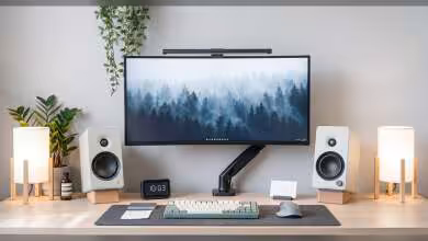 Bureau avec deux enceintes Creative XF1 blanches, écran PC et lampes de chaque côté